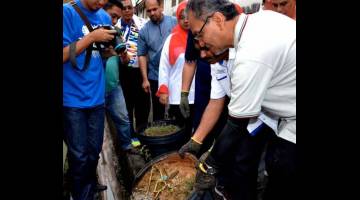 PEMERIKSAAN KAWASAN: Dzulkefly (kanan) membuang takungan air dalam bekas ketika melakukan pemeriksaan di kawasan perumahan selepas merasmikan Program Gotong-Royong Mega 2.0 Perangi Aedes Peringkat Kebangsaan 2018 di Taman Saujana Seksyen 2, Melaka, semalam. — Gambar Bernama