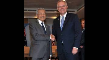 PERJANJIAN DUA HALA: Dr Mahathir (kiri) bersalaman dengan Scott ketika mesyuarat dua hala antara kedua-dua negara sempena Sidang Kemuncak ASEAN ke-33 di Pusat Konvensyen dan Pameran Antarabangsa Suntec Singapura, semalam. — Gambar Bernama