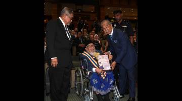 Muhyiddin menyampaikan Pingat Jasa Pahlawan Negara 2014 kepada pesara polis Datuk Abdul Majid Ahmad (berkerusi roda) pada Majlis Amanat Tahun Baharu KDN Tahun 2019 hari ini. - Gambar Bernama 