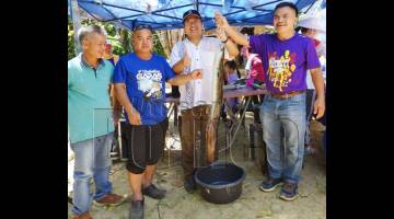 EWON (tengah) menunjukkan ikan sungai (sinsilog), hasil tuaian pada program itu.