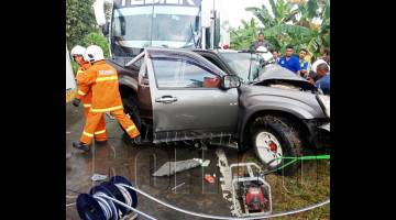 ANGGOTA bomba semasa menjalankan operasi mengeluarkan mangsa tersepit di bahagian penumpang hadapan.