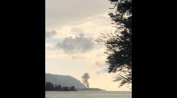 MALANG: Kepulan asap kelihatan sejurus selepas nahas pesawat itu seperti yang dapat dilihat dari Taman Pantai Teluk Kaiaka di Haleiwa, Hawaii pada Jumaat lalu dalam imej daripada media sosial. — Gambar Reuters
