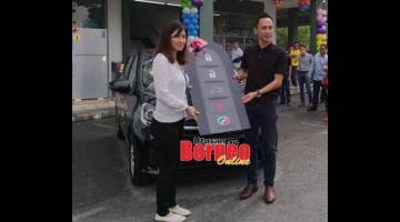 TUAH BADAN: Lam (kiri) menerima replika kunci kereta Perodua Axia daripada Pengurus Bahagian Jualan Nestle Products Sdn Bhd, Jimmy Ngui (kanan) di UNACO Stutong semalam.