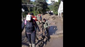 MISI MENYELAMAT: Gambar serahan yang dikeluarkan oleh Angkatan Tentera Colombia ini menunjukkan askar membantu penduduk tempatan selepas limpahan air sungai akibat hujan lebat memusnahkan sebuah perkampungan kecil di Chaparral, bahagian Tolima, Colombia kelmarin. — Gambar AFP