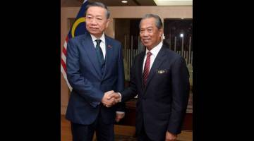 MESRA: Muhyiddin  (kanan) bersalaman dengan To Lam ketika menerima kunjungan hormat Menteri Keselamatan Awam Vietnam di Kementeriannya semalam. — Gambar Bernama