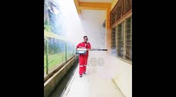 CEGAH: Pasukan task force Parlimen Sandakan melakukan semburan kabus pembunuh nyamuk aedes di sekolah.