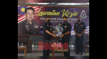 KENANGAN: Hazani menerima cendera kenangan daripada Haris semasa lawatan kerja di IPD Penampang.