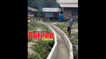TUNJUK: Julas menunjukkan parit konkrit yang telah siap dilaksanakan untuk kemudahan penduduk kampung Liau Ulu.