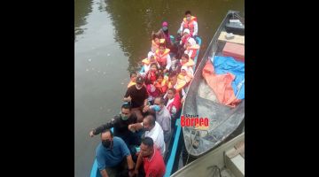 SESAK: Harun (tiga kiri) turut sama menaiki perahu yang digunakan murid SK Mangkapon semasa lawatan itu.