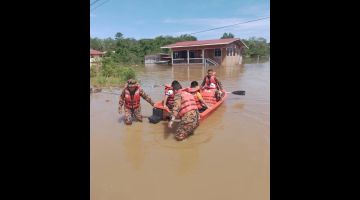 PINDAH: Pasukan bomba semasa memindahkan salah sebuah keluarga terjejas banjir.