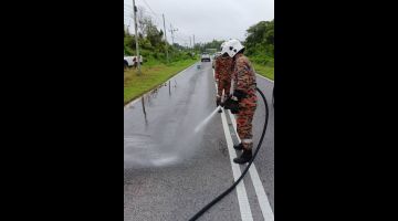 Anggota bomba membersihkan sisa tumpahan minyak di Jalan Kelupu, Sungai Jabai, Bintangor hari ini.