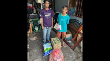 Catherine (kanan) bersama salah seorang anaknya menerima bantuan daripada Hope Place Kuching.